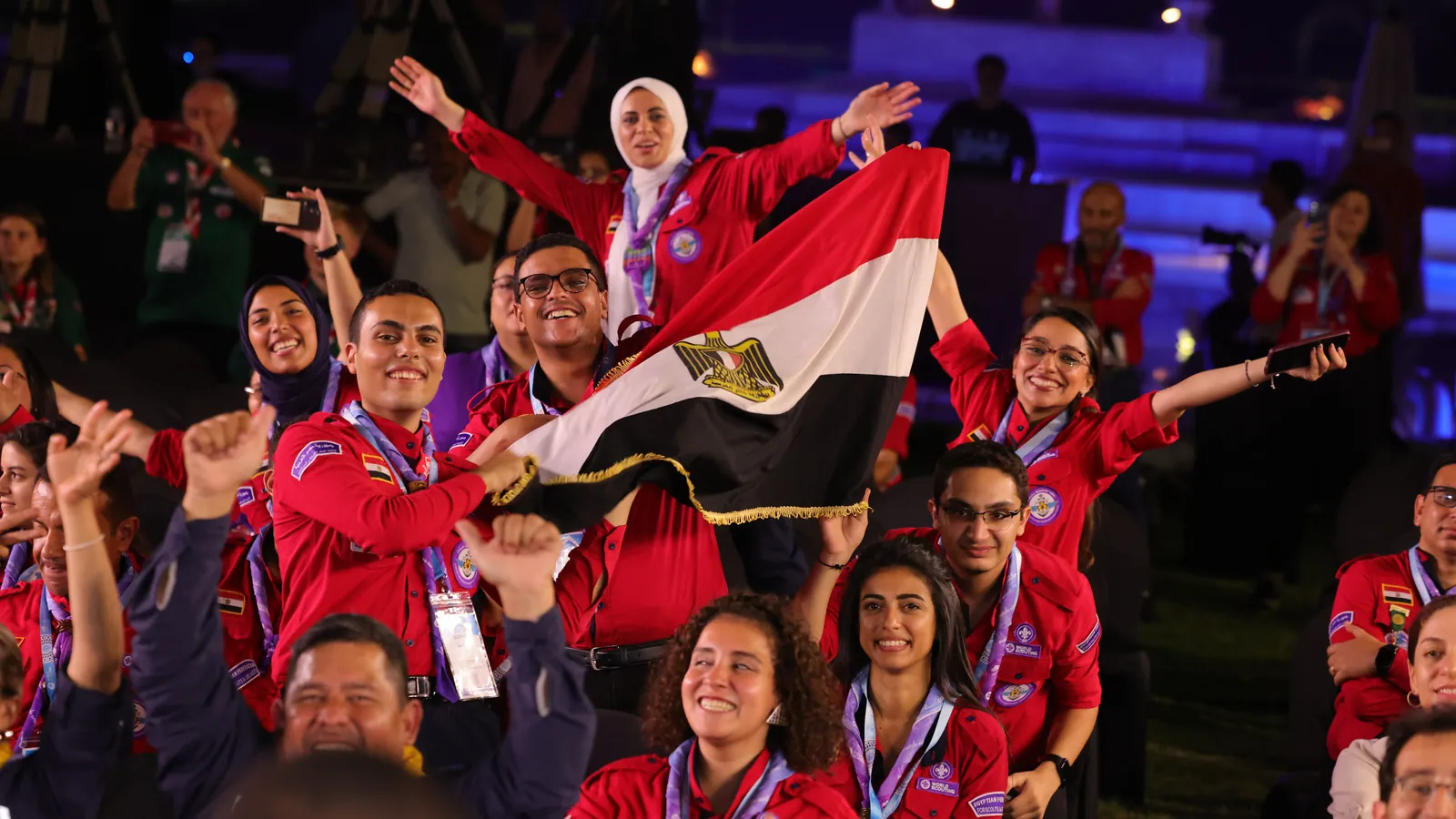 الوفد المصري بالزي الأحمر يهتف رافعاً علم البلاد