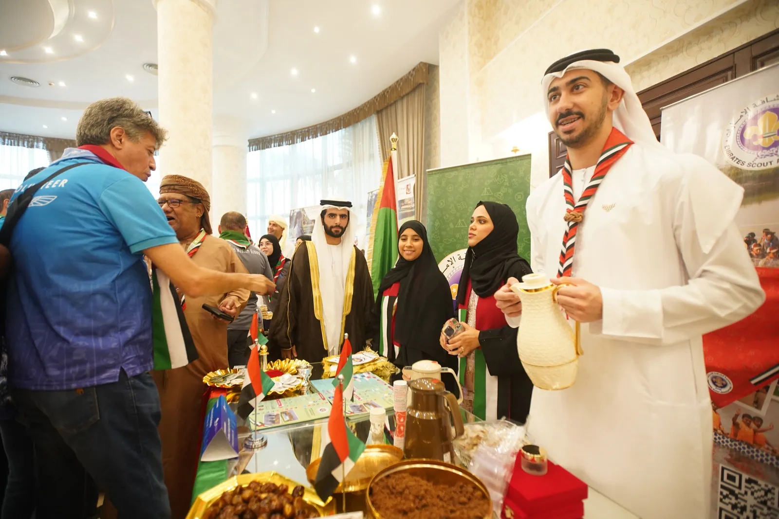 كشاف إماراتي بالكندورة البيضاء يستقبل الزوار في ركن ثقافي