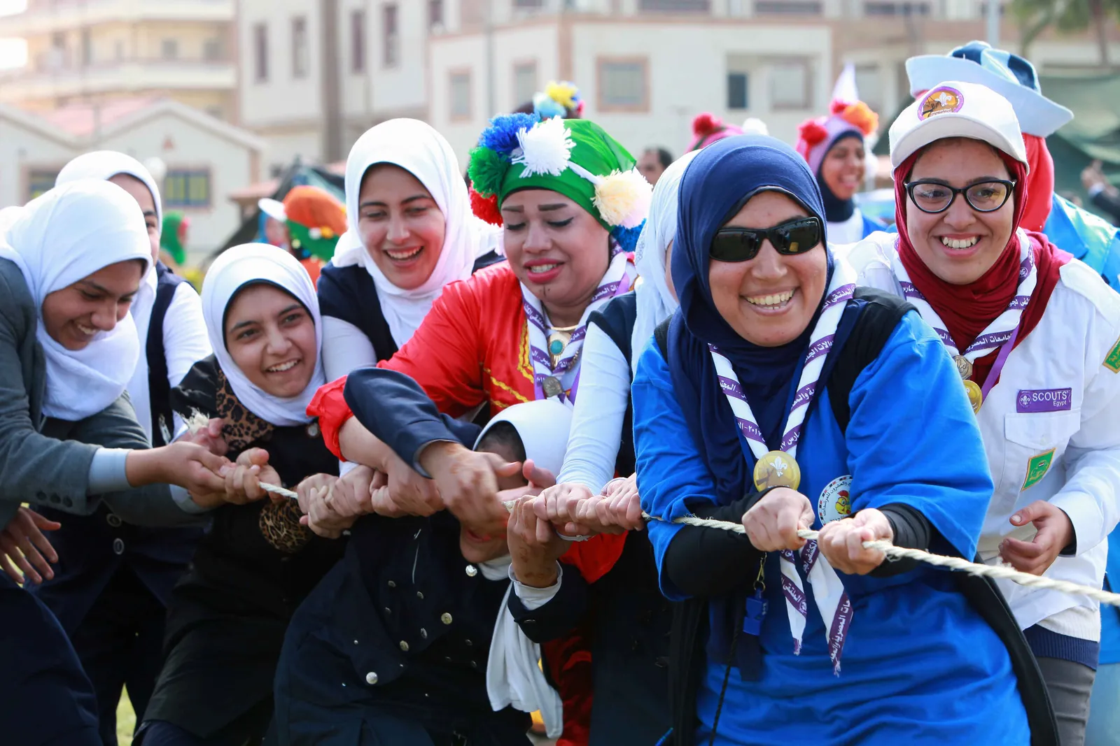 كشافات محجبات يشددن معاً على حبل شد الجذب